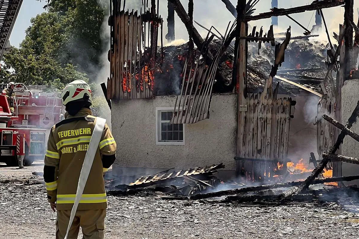 Feuerwehrmann vor brennendem Bauernhaus in Köstendorf