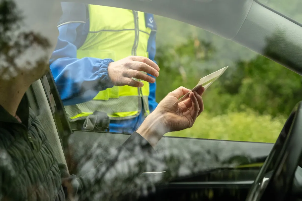 Fahrer übergibt Ausweis bei Verkehrskontrolle der Polizei