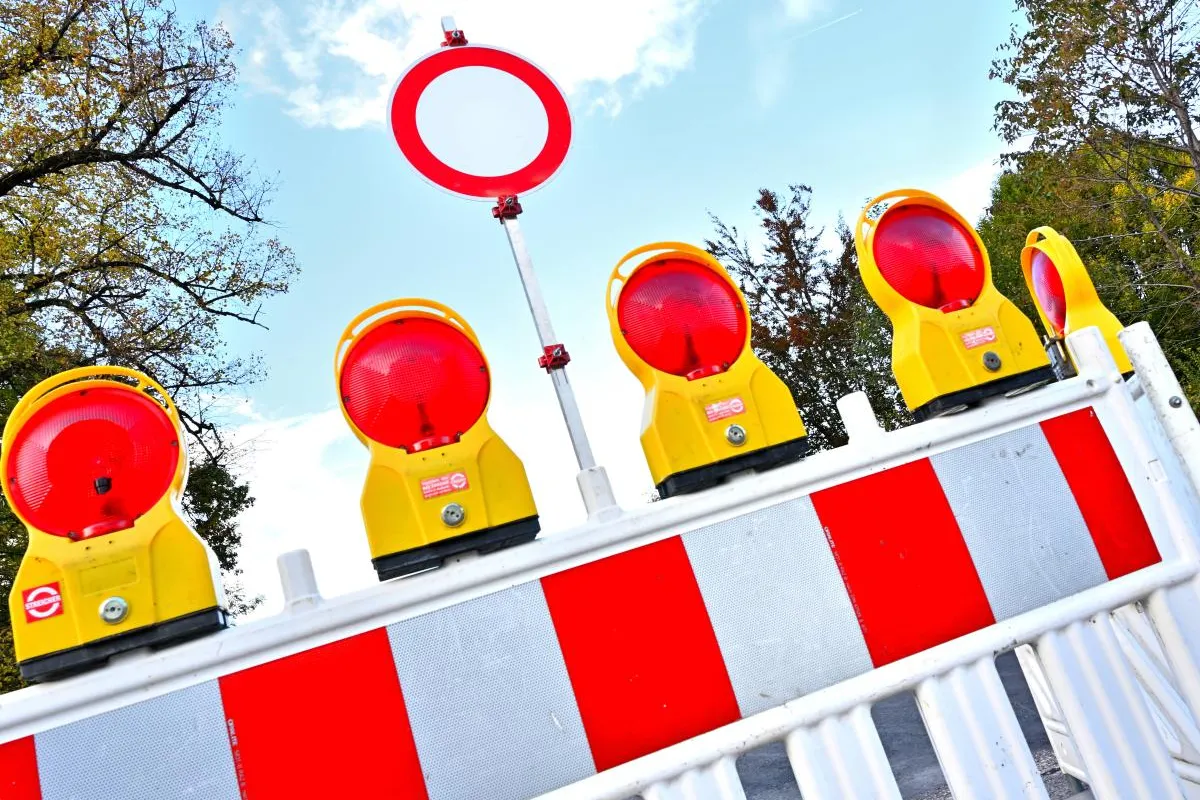 Absperrung mit roten Warnleuchten und Verbotsschild bei Strassensperrung