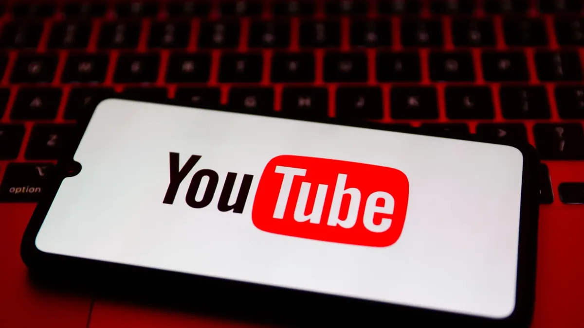 YouTube-Logo auf Smartphone vor Tastatur – Symbol für Medienplattform