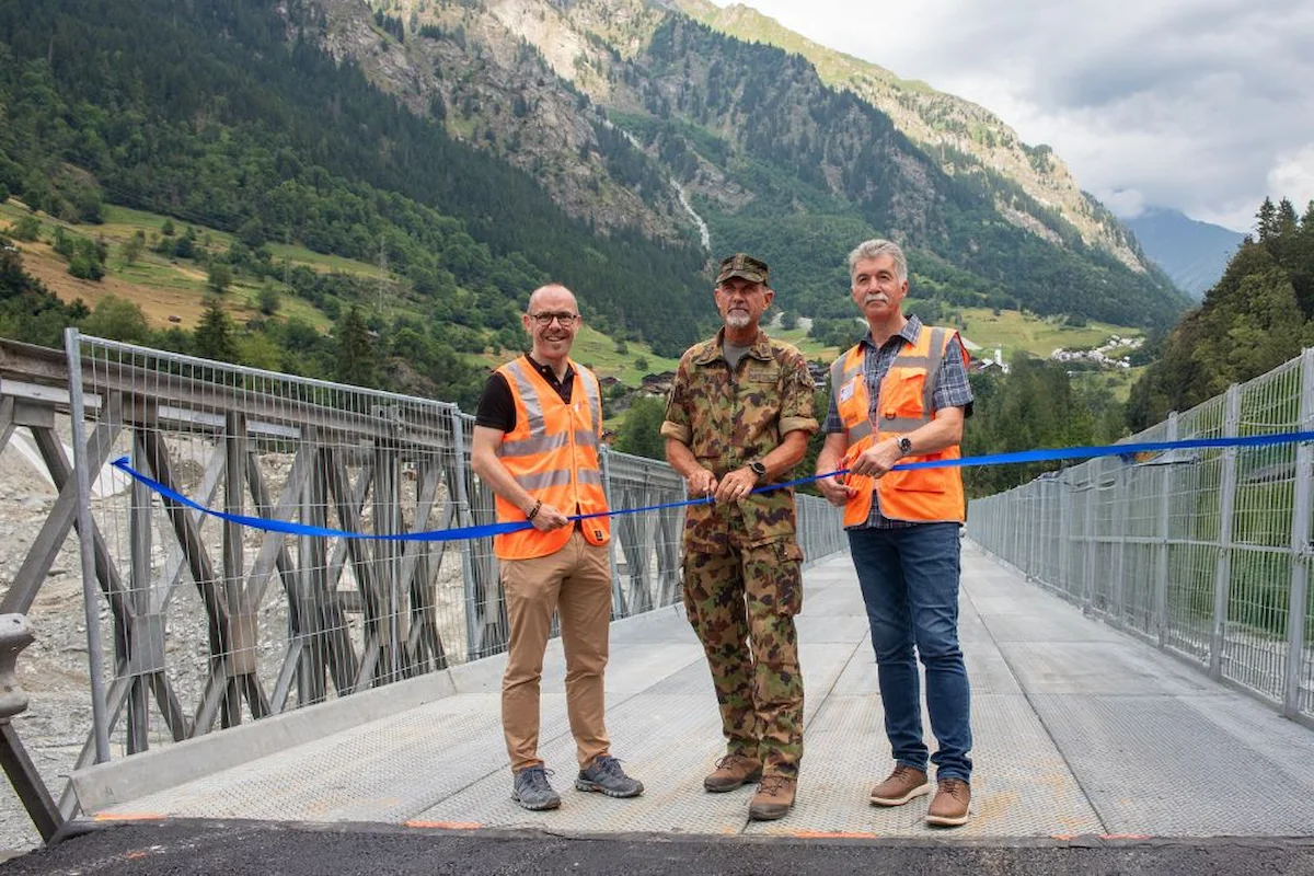  Drei Vertreter bei symbolischer Eröffnung der Militärbrücke mit Banddurchschnitt