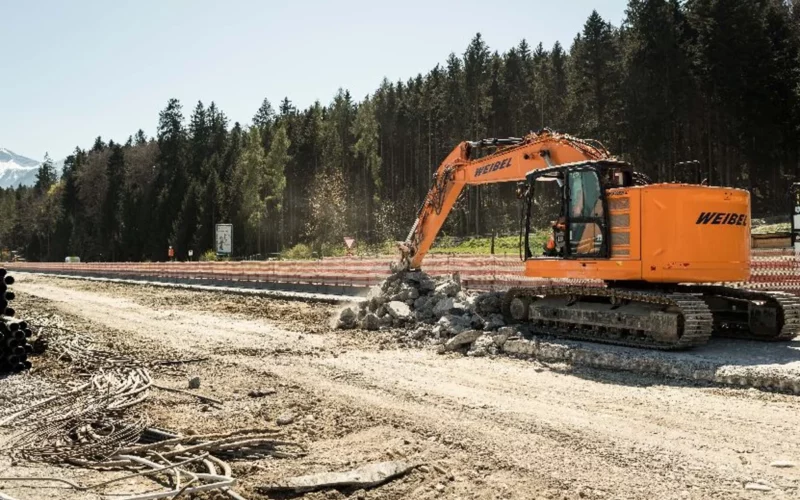 Bagger beim Abbruch von Betonplatten auf einer Autobahnbaustelle