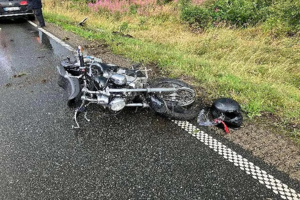 Gestürztes Motorrad auf nasser Strasse bei Braunlage, daneben ein beschädigter schwarzer Helm