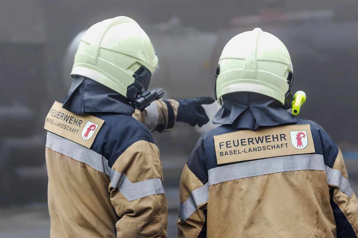 Zwei Feuerwehrleute Basel-Landschaft mit Schutzkleidung bei Einsatzbesprechung
