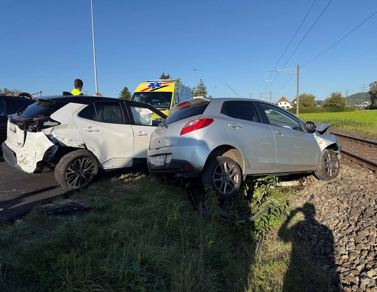 Heftige Auffahrkollision in Suhr: beschädigter Toyota und Mazda nahe der Bahnlinie, Einsatzkräfte vor Ort