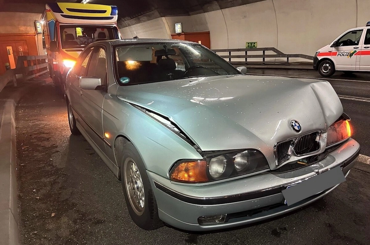 Unfall im Fäsenstaubtunnel in Schaffhausen: BMW mit Frontschaden, Ambulanz und Polizeifahrzeug im Hintergrund.