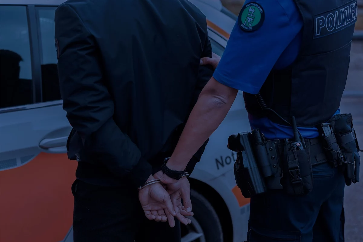 Polizist der Kantonspolizei St.Gallen nimmt Person bei Nacht fest